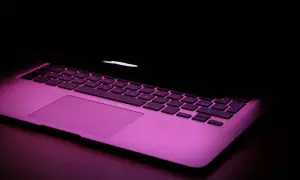 Klawiatura MacBooka w różowym świetle. Chcesz wiedzieć, jak zrobic @ na macbook? To proste: Option + 2.